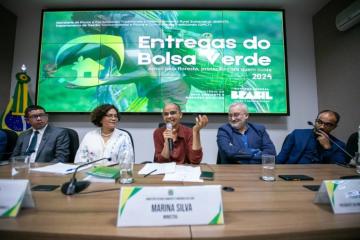Four people on a panel with a screen behind them.