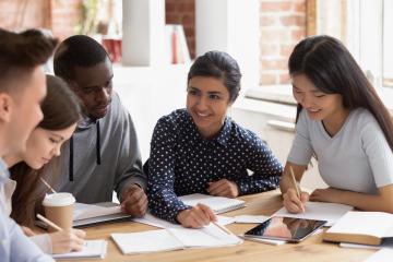 A group of people working together on a round table.