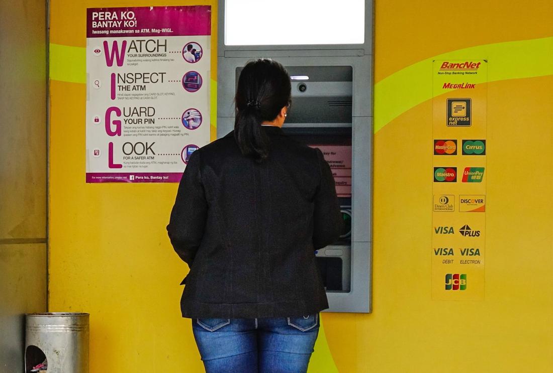 Woman using ATM in the Philippines