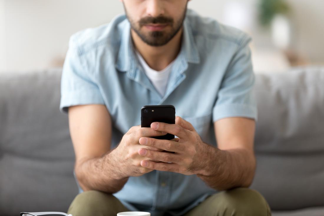 man holding cell phone in front of him