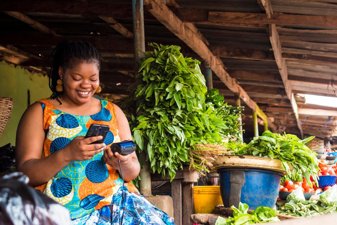 Woman making mobile credit payment in Nigeria.