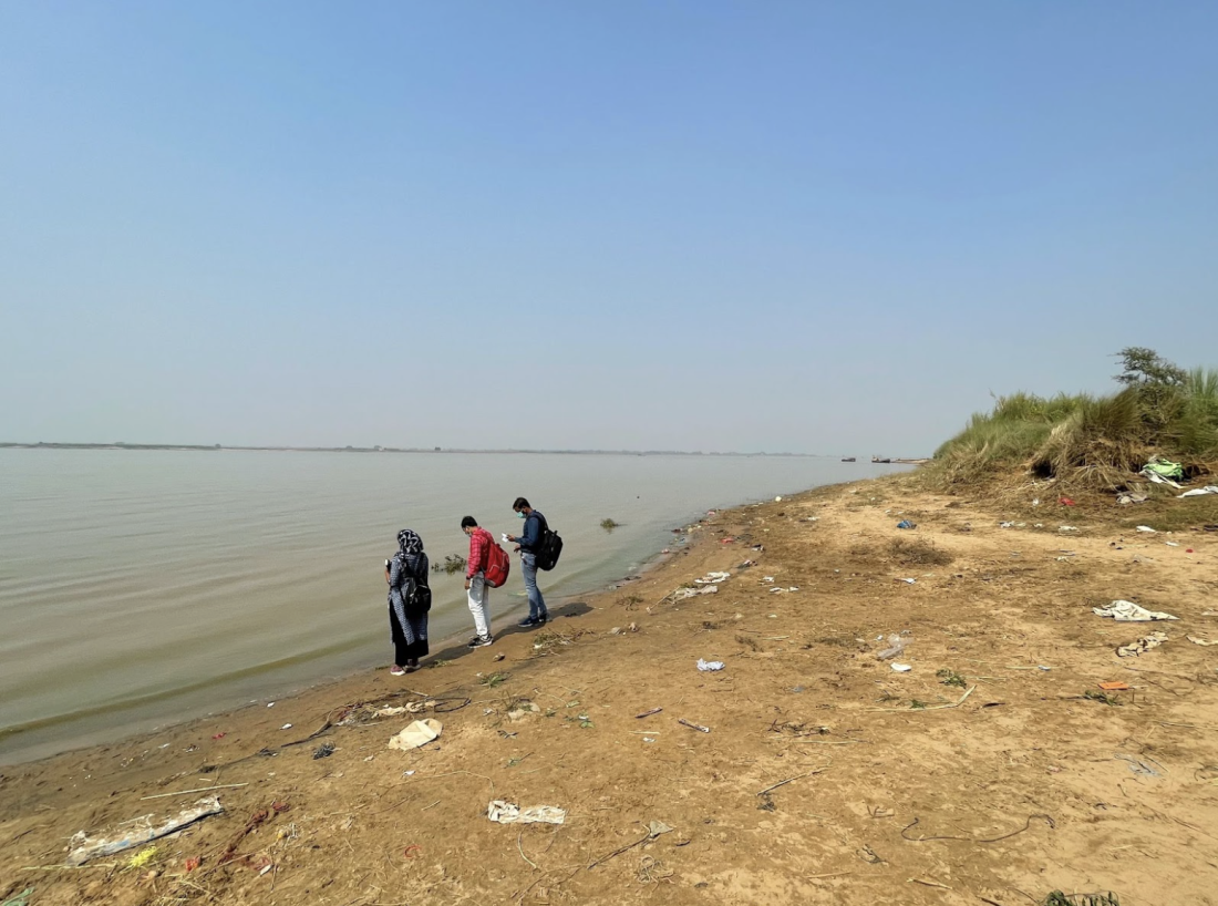 People standing at the flooded bank of the Kosi river