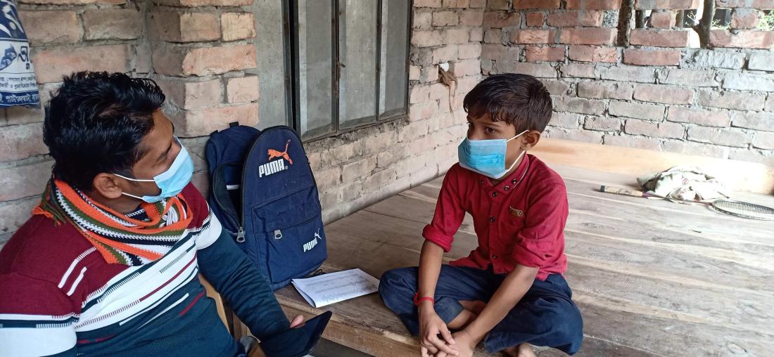 A man is speaking with a child about school