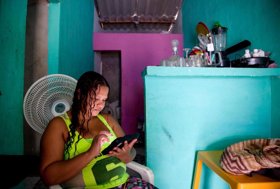 A woman looks at her mobile phone.