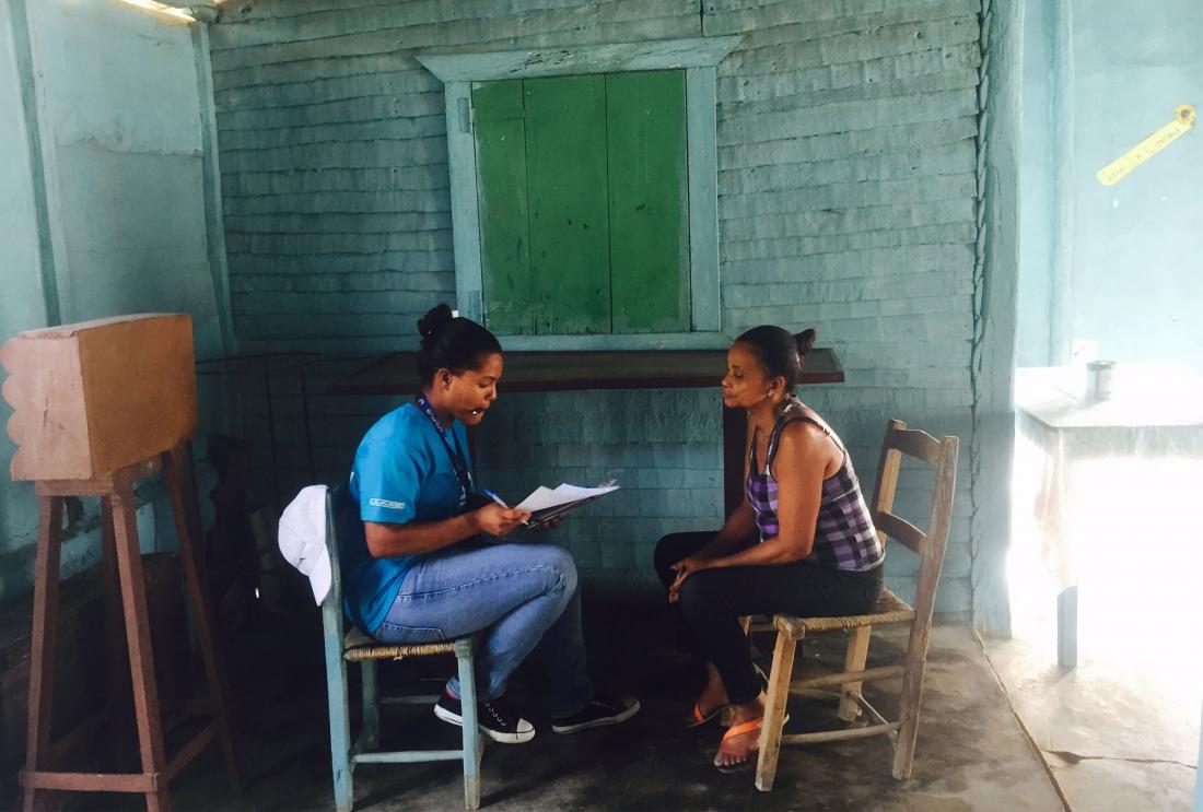 Two women sit on chairs facing each other having a conversation