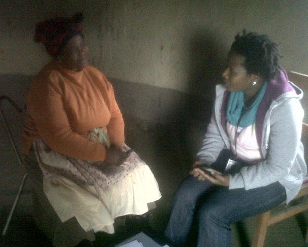 Two women in chairs talking inside house