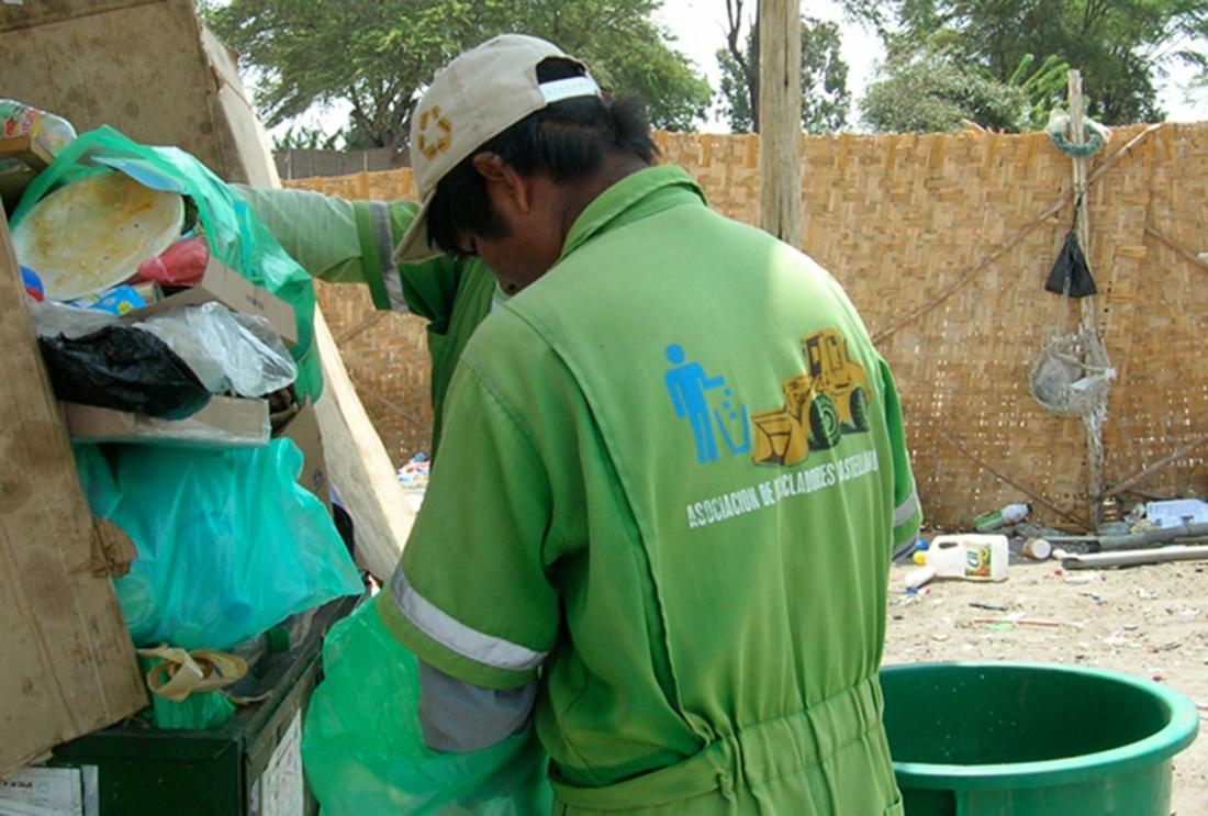 Man in jumpsuit puts recycling into truck