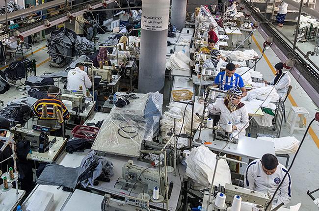 Garment factory with men working at sewing machines