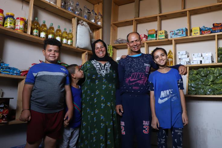 Family standing in front of shelves in their shop