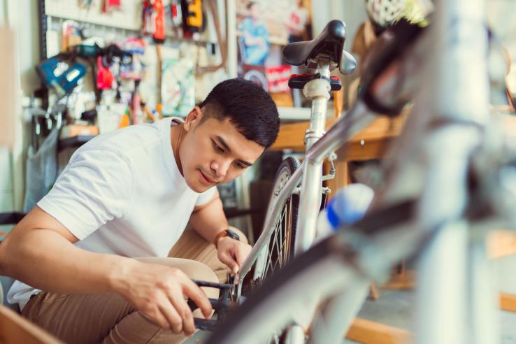 Young man fixes a bicycle