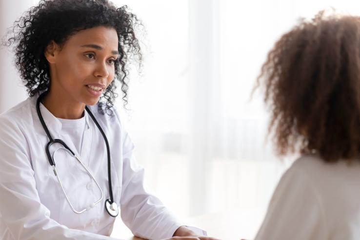 Female African American doctor speaks to patient