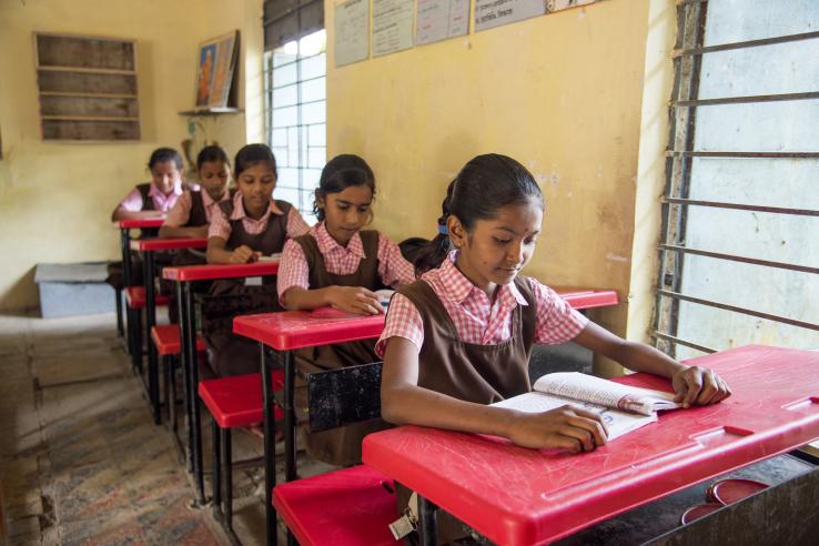 student learning from books in the classroom of their school, scene in a rural or small village school in India