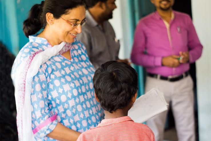 Smiling woman looks at child's school work