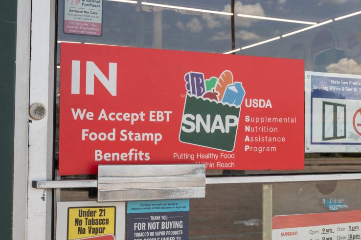 Sign on a storefront reading "We Accept EBT Food Stamp Benefits"