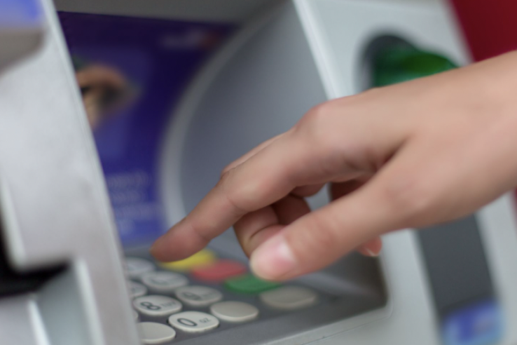 Hand using an ATM