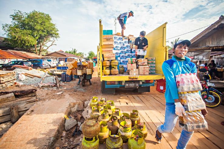 Workers transfer goods from trucks