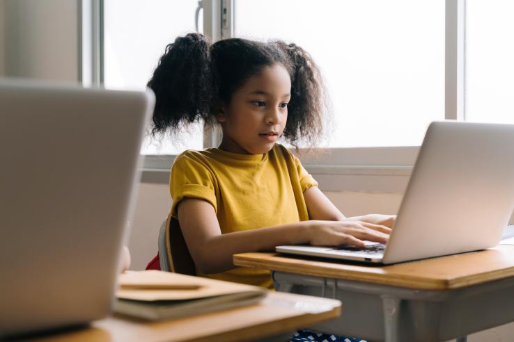 Young girl using a computer in a classroom