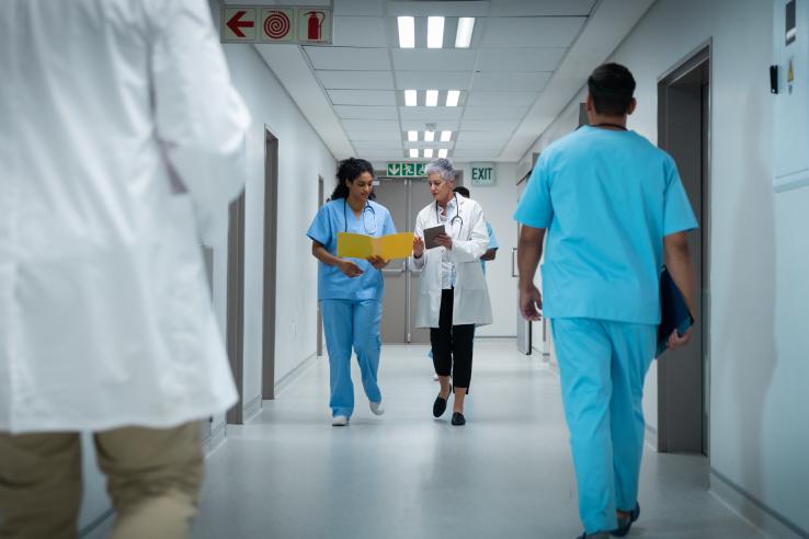 Photo of a hospital hallway with multiple doctors walking.