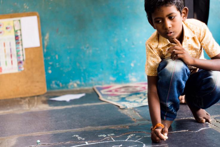 A boy pauses in thought while working on his schoolwork