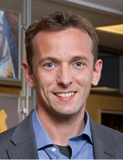 Headshot of Martin Abel wearing a blue shirt and grey blazer