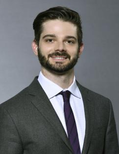 headshot of Sean Higgins wearing a black suit