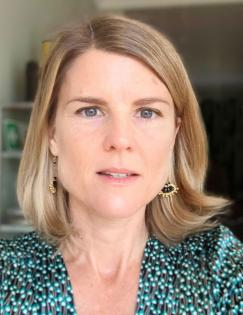 A head shot featuring a photo of Cally Ardington. She is wearing a green shirt and has brown shoulder length hair. 