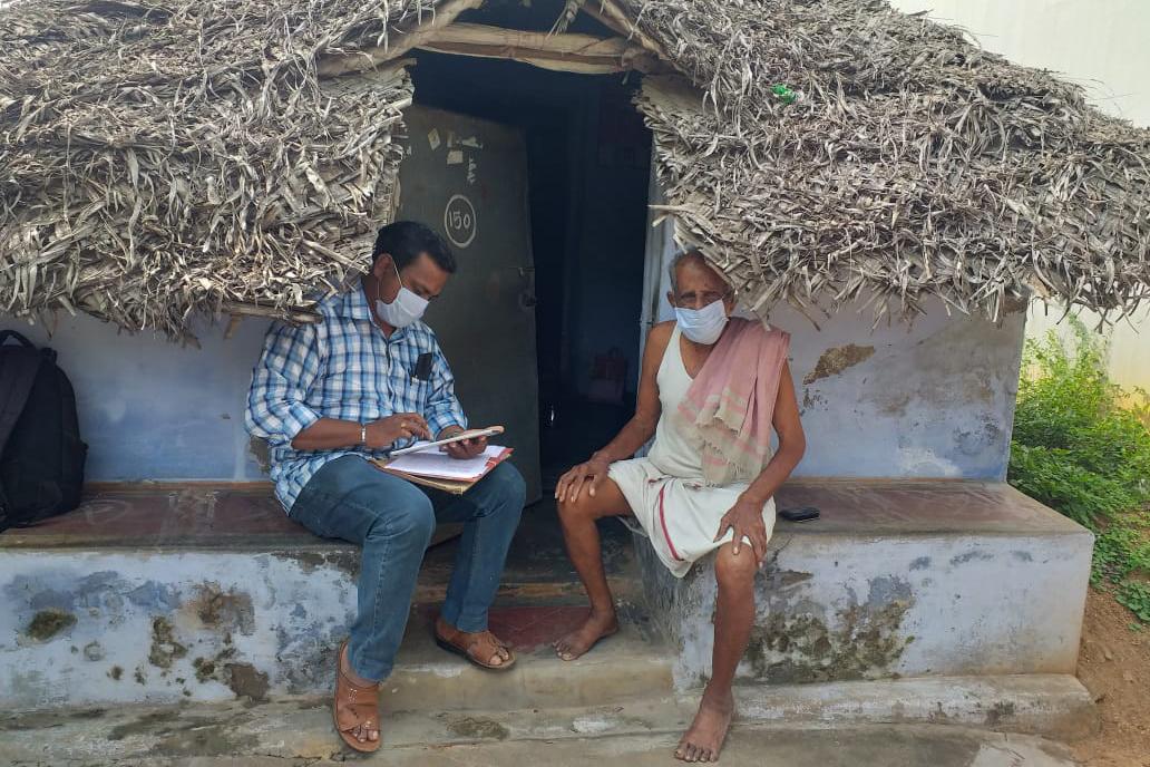 Two men sitting; one is being interviewed by a surveyor