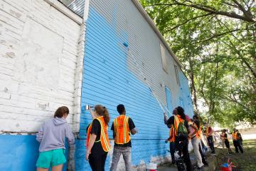 Youth help paint a wall