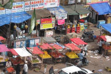 Street scene with fruit vendors and electronics stalls in Hyderabad, India