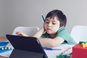 A young boy studying using a tablet