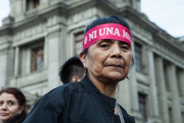 A person stands at a protest for women's rights.