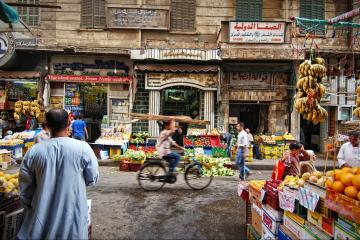 A street with fruit stands and sellers.