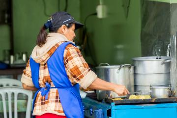 Mujer cocinando en un puesto