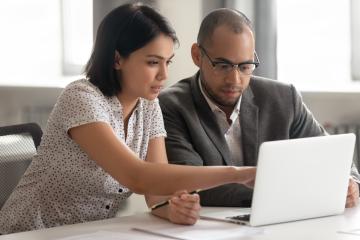 Man and woman look at laptop