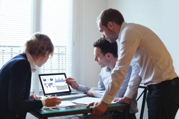 Three people looking at a computer screen