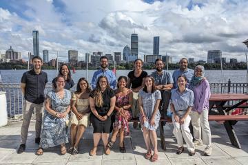 A group photo of the North America DEI Working Group in front of the Boston skyline