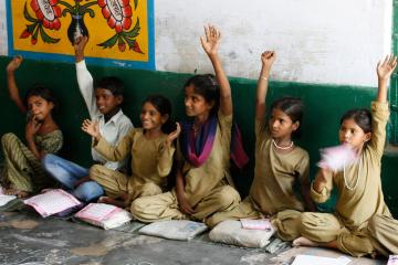 Schoolchildren in India raise their hands