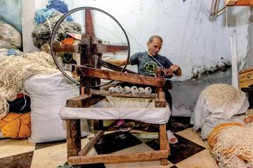 A man weaves a rug. Photo Credit: Haitham Fahmy | J-PAL